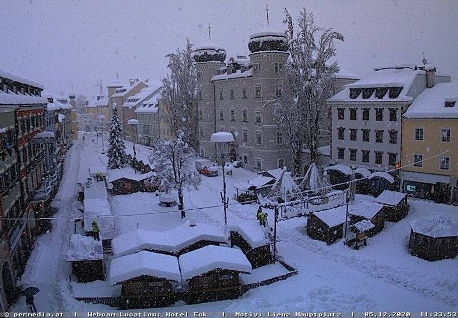 In Lienz worden daken van de kerstmarkt sneeuwvrij gemaakt omdat de sneeuw te zwaar werd