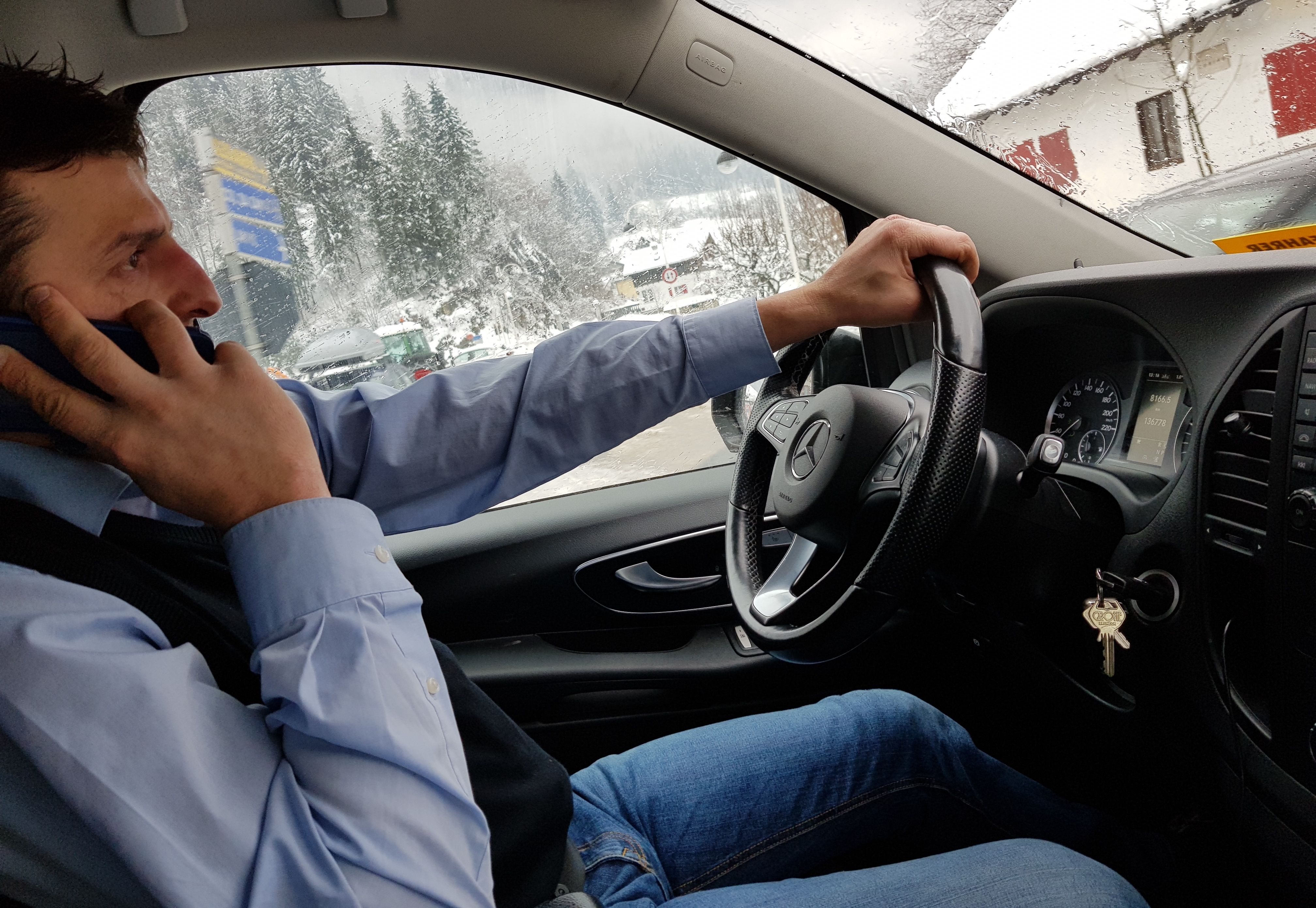 Mijn taxichauffeur druk telefonerend met Britse vakantiegasten die door zijn collega in Innsbruck opgepikt zouden worden