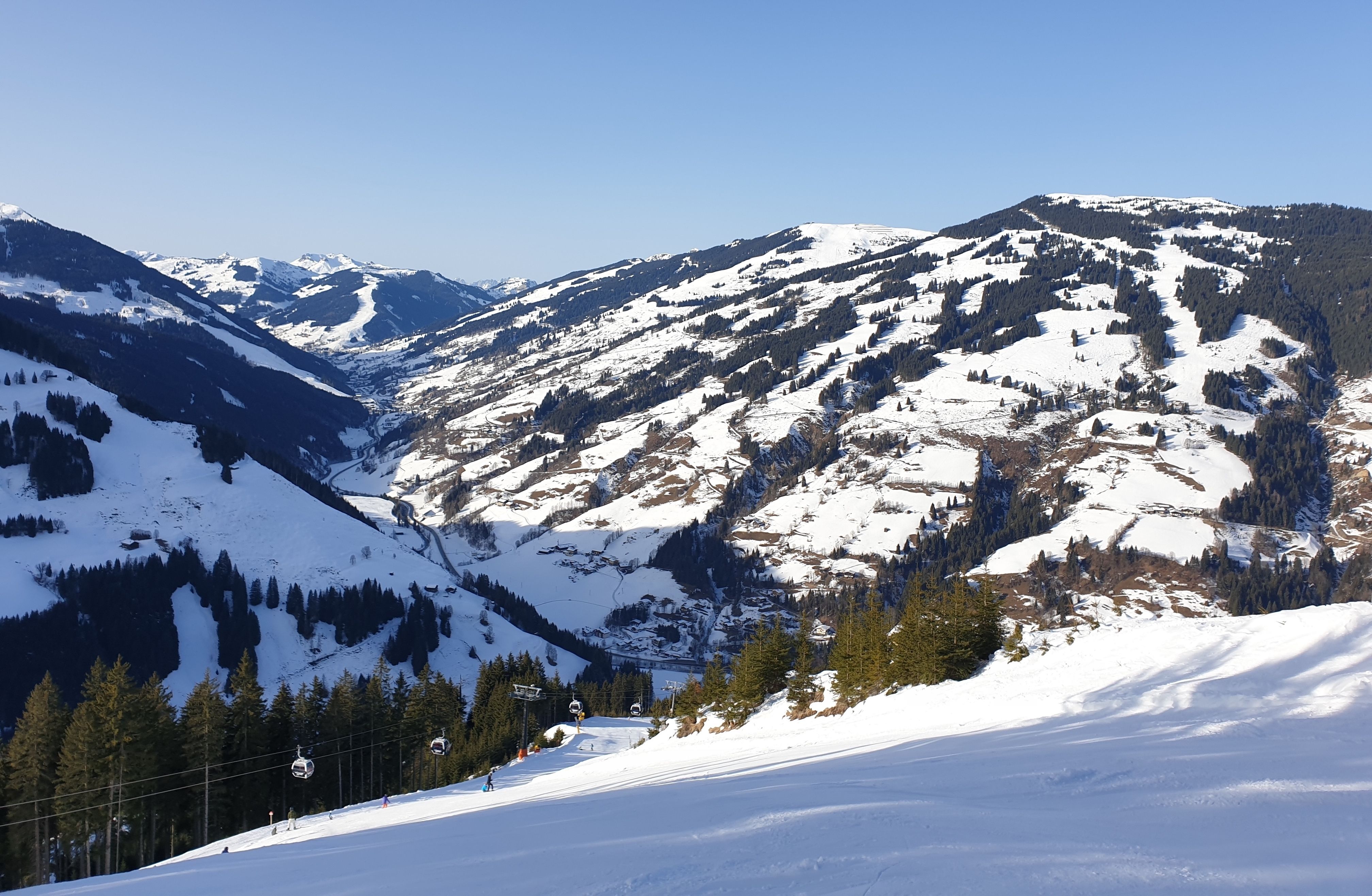 Piste 21 met de ZellamseeXpress en uitzicht op het skigebied van Saalbach, rechts de piste naar Viehhofen